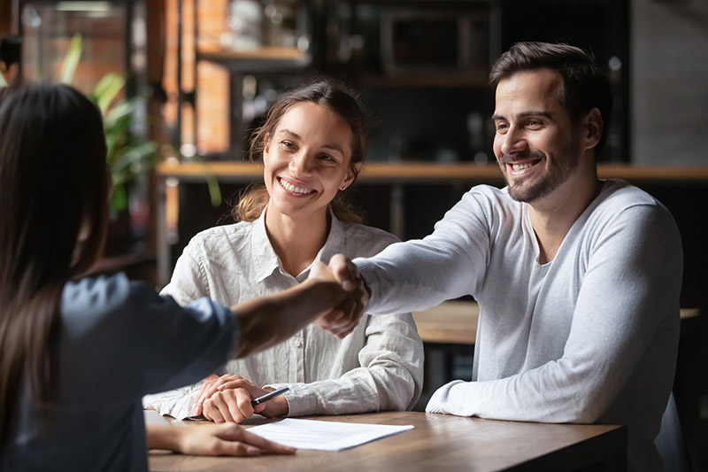 Couple shaking hands with their new Colorado Springs mortgage broker.