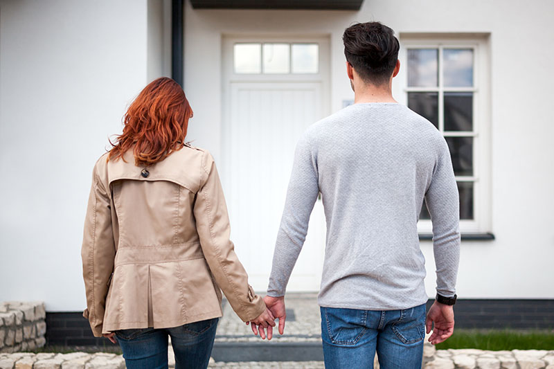 Couple looks at their front door after closing on their new home.