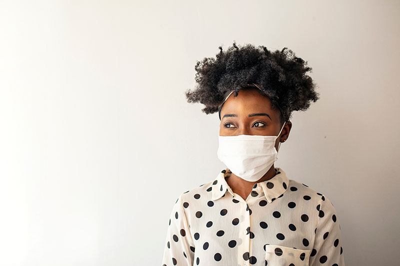A Woman Wears A Face Mask While Showing Her Home.