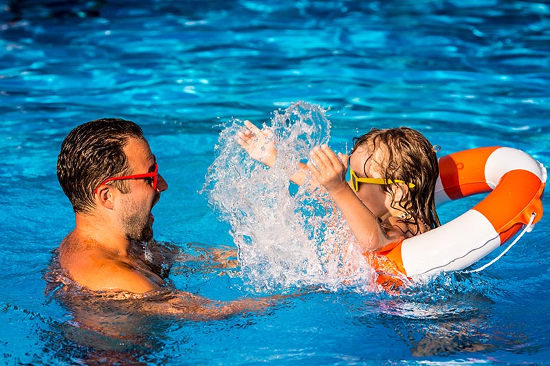 A family plays in a home pool during the covid-19 pandemic.